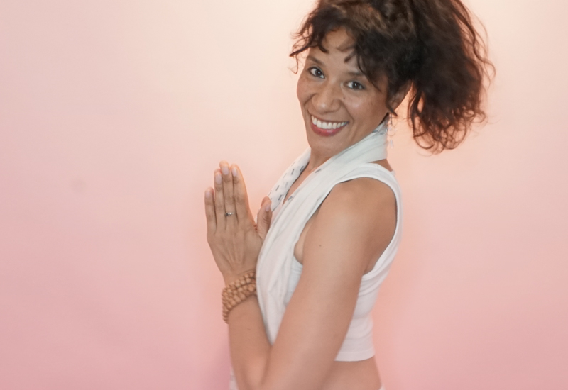 Charisma Whitefeather, Kundalini Yoga teacher in Los Angeles, holding her hands in prayer pose and smiling